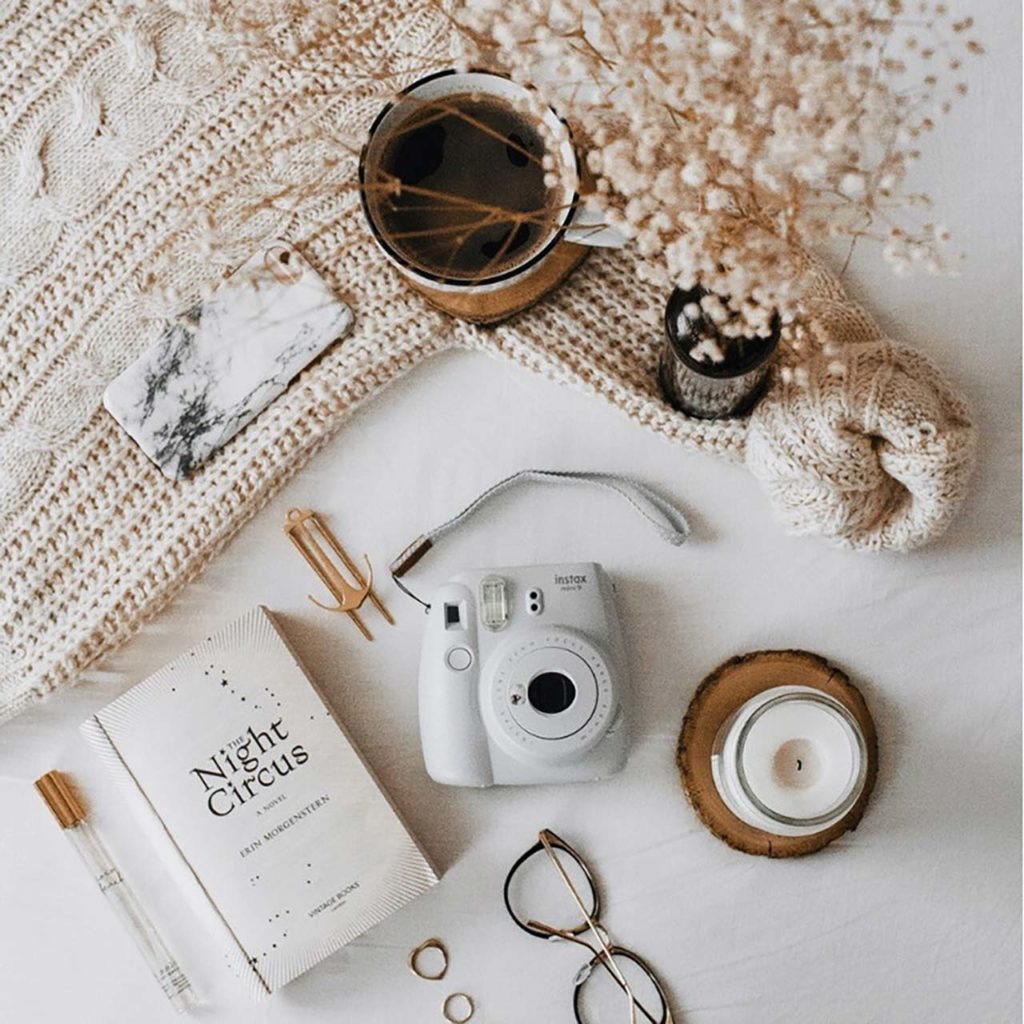 Flat-lay billede med hvid baggrund og instax mini 11 liggende på bordet