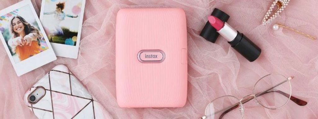 Rosa instax mini Link-skrivare omgiven av tillbehör